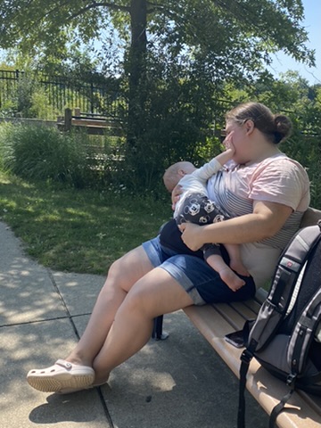 Makayla holding a baby on a park bench